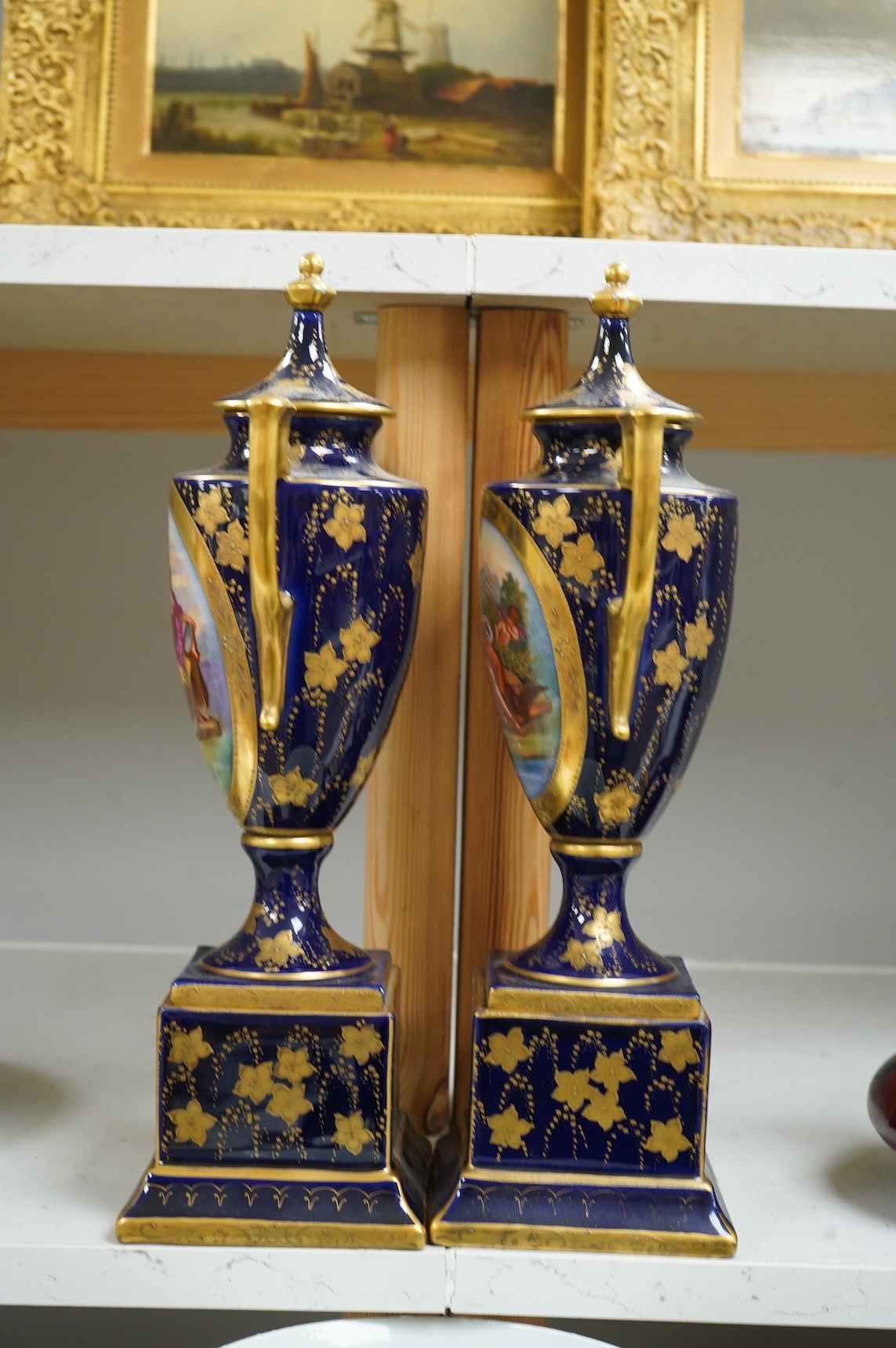 A pair of early 20th century Vienna style porcelain urns and covers, 36cm